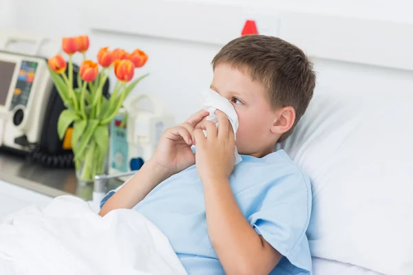 Boy blowing nose into tissue — Stock Photo, Image