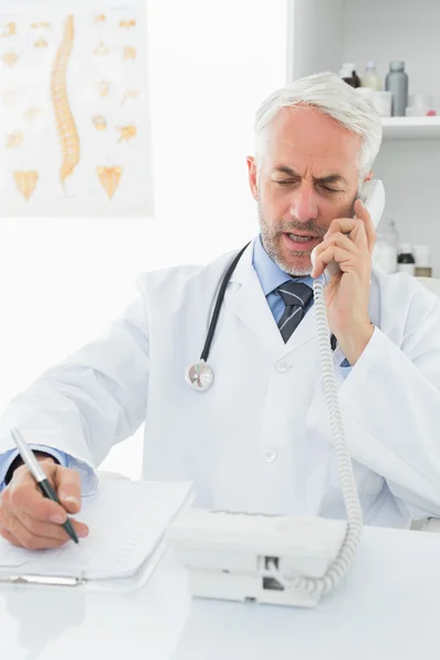 Hombre médico escribiendo informes mientras está de guardia — Foto de Stock