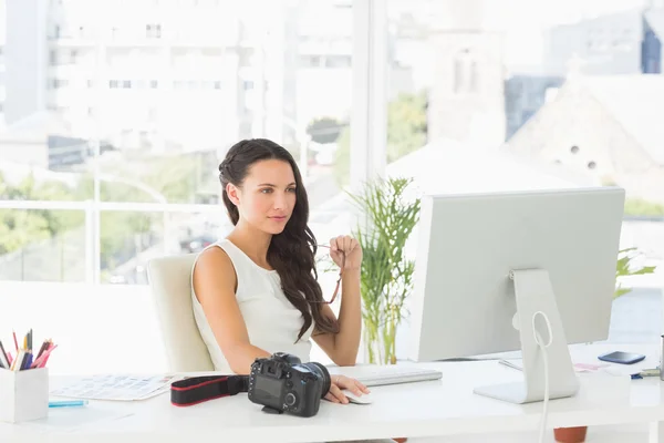 Beautiful focused photographer working at her desk — Stock Photo, Image
