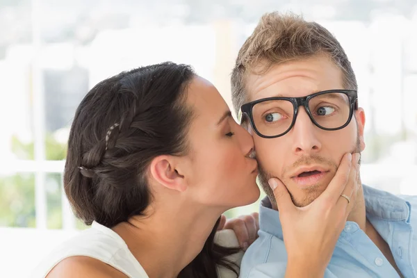 Surprised young designer getting a kiss from a co worker — Stock Photo, Image