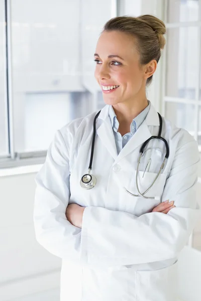 Beautiful female doctor with arms crossed in hospital — Stock Photo, Image