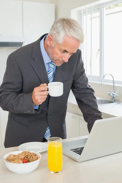 Homme d'affaires concentré utilisant un ordinateur portable le matin avant le travail — Photo