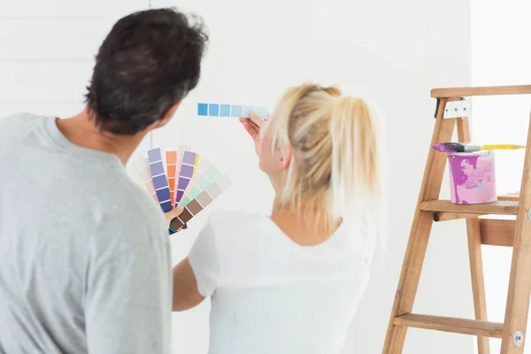 Casal escolher a cor para pintar uma sala — Fotografia de Stock