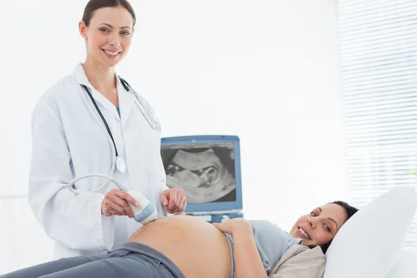 Doctor performing ultrasound on woman — Stock Photo, Image