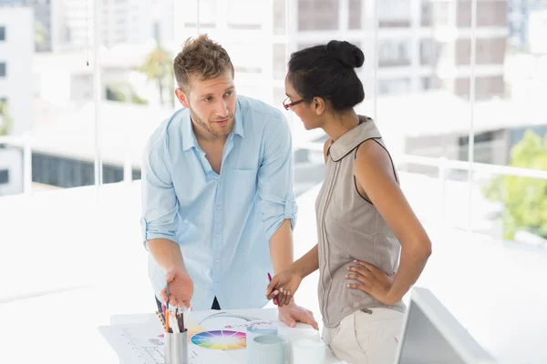 Interior designers looking at colour wheel and talking — Stock Photo, Image