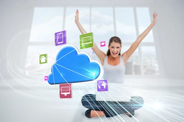 Cheering blonde using laptop with app icons and cloud — Stock Photo, Image