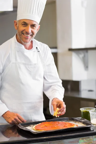 Усміхнений чоловічий шеф-кухар прикрашає їжу на кухні — стокове фото