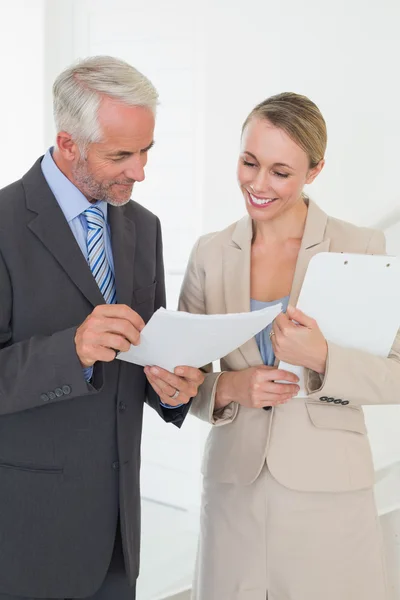 Sorrindo agente imobiliário indo sobre contrato com o cliente — Fotografia de Stock