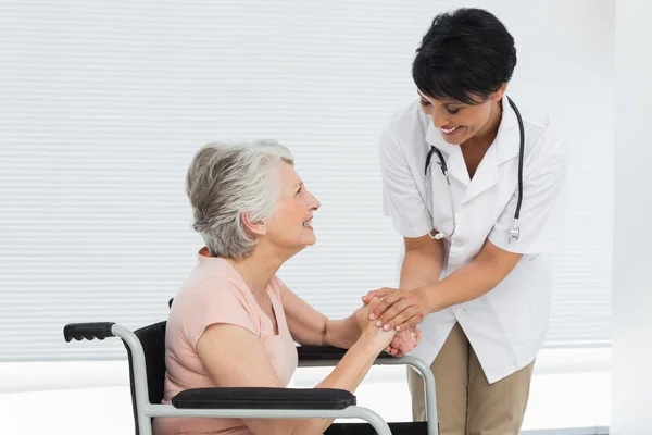 Kadın doktor tekerlekli sandalye üst düzey bir hastada konuşuyor — Stok fotoğraf