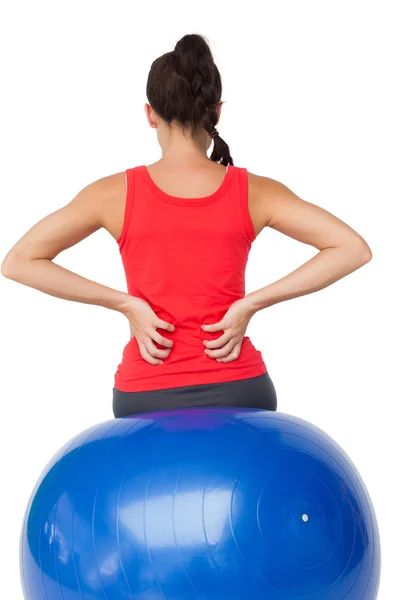 Vue arrière d'une jeune femme en forme assise sur un ballon d'exercice — Photo