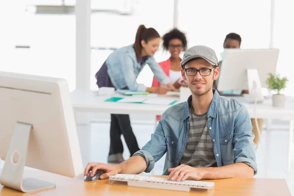 Artiste masculin occasionnel utilisant l'ordinateur avec des collègues — Photo