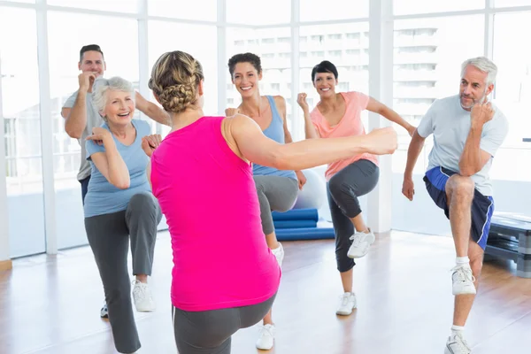 Pessoas fazendo exercício de fitness de poder na aula de ioga no estúdio de fitness — Fotografia de Stock
