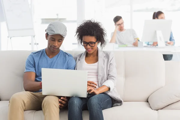 Coppia utilizzando computer portatile con i colleghi — Foto Stock