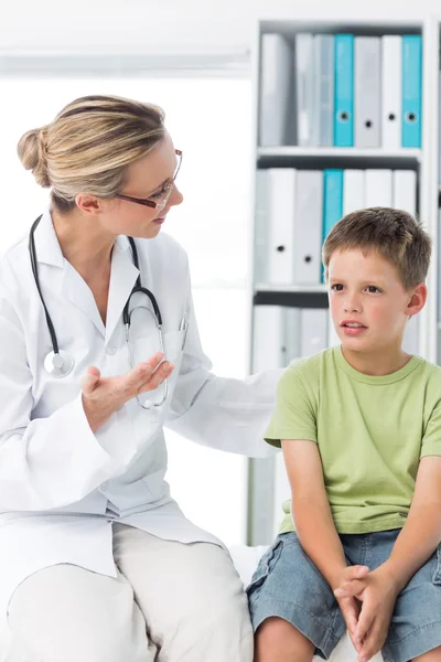 Doctor talking with boy in clinic — Stock Photo, Image