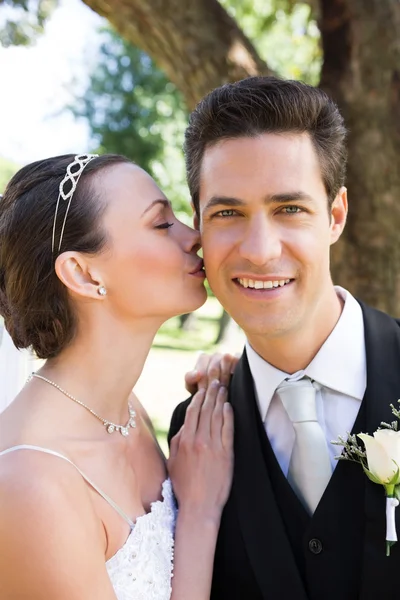 Noiva beijando noivo na bochecha — Fotografia de Stock