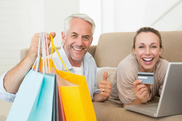 Glückliches Paar shoppt online auf der Couch — Stockfoto