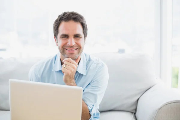 Homme heureux en utilisant ordinateur portable souriant à la caméra — Photo