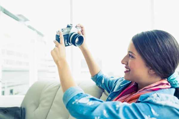 Brünette sitzt auf Sofa und macht ein Selfie — Stockfoto