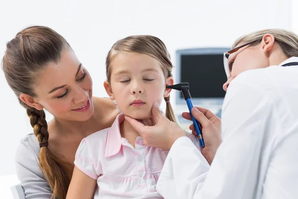 Girl being examined by doctor Stock Image