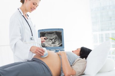 Doctor doing ultrasound pregnant woman clipart