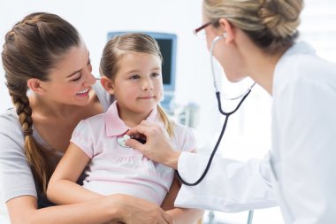 Girl being examined by female pediatrician clipart
