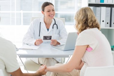 Gynaecologist talking to expectant couple clipart
