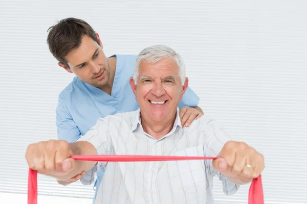 Мужской физиотерапевт массирует спину пожилым мужчинам — стоковое фото