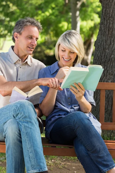 Paar liest Bücher auf Bank — Stockfoto