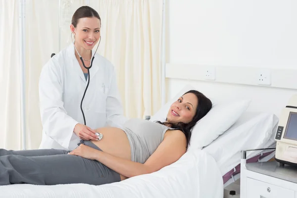 Médico verificando mulher grávida — Fotografia de Stock