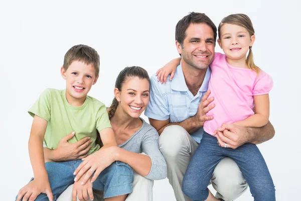 Família bonito posando e sorrindo para a câmera juntos — Fotografia de Stock