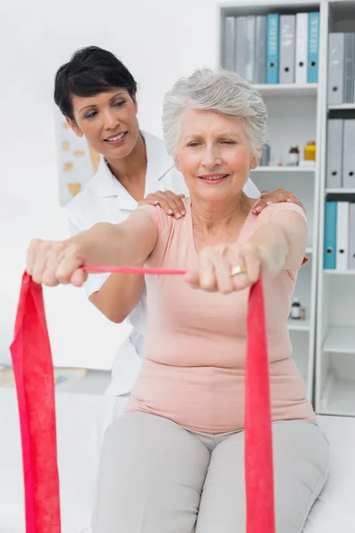 Female physiotherapist massaging senior womans back — Stock Photo, Image