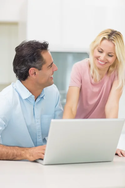 Casal usando laptop na cozinha — Fotografia de Stock