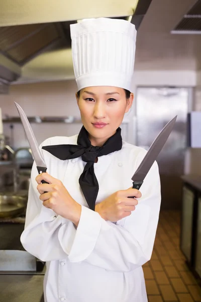Cook holding knives in kitchen — Stock Photo, Image