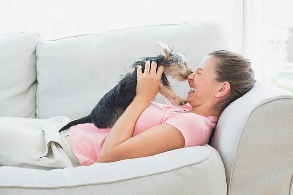 Gelukkige vrouw spelen met haar yorkshire terriër op de Bank — Stockfoto