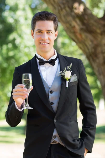 Brudgum innehav champagne flöjt — Stockfoto