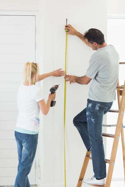 Couple with drill and tape — Stock Photo, Image