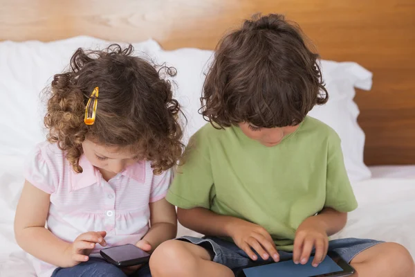 Kinderen met behulp van digitale Tablet PC en mobiele telefoon — Stockfoto