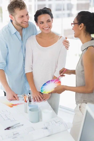 Interior designer showing colour wheel to happy clients — Stock Photo, Image