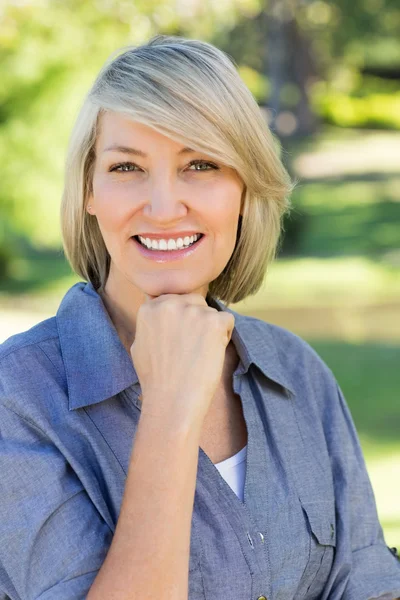 Vrouw met hand op kin in park — Stockfoto