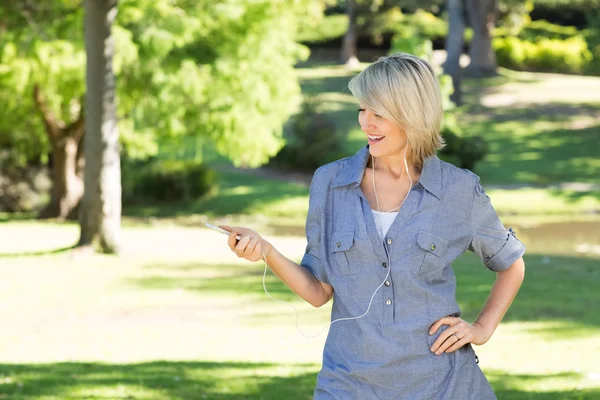 Mujer disfrutando de la música en parque — Foto de Stock