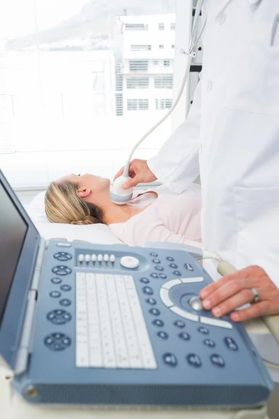 Médico realizando ecografía en el cuello del paciente — Foto de Stock