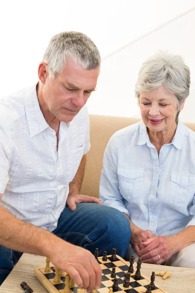 Seniorenpaar sitzt auf Sofa und spielt Schach — Stockfoto