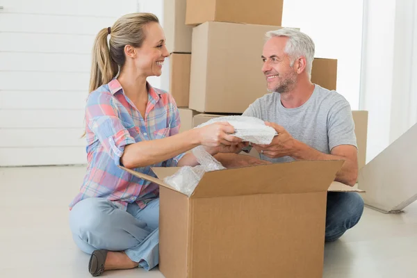 Happy couple unpacking cardboard moving boxes — Stock Photo, Image