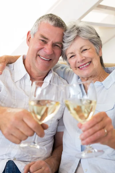 Äldre par sitter på soffan med vitt vin — Stockfoto