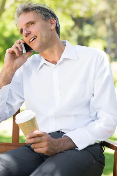 Homme d'affaires utilisant un téléphone portable au parc — Photo