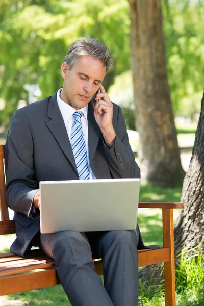 Businessman answering cellphone — Stock Photo, Image