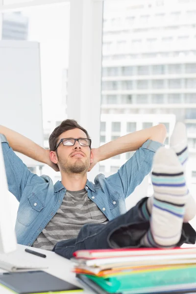 Casual jongeman met benen op balie in kantoor — Stockfoto