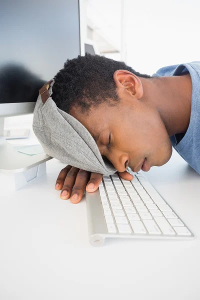 Мужчина-художник с головой, лежащей на клавиатуре в офисе — стоковое фото