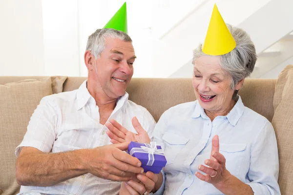 Coppia anziana seduta sul divano per festeggiare un compleanno — Foto Stock