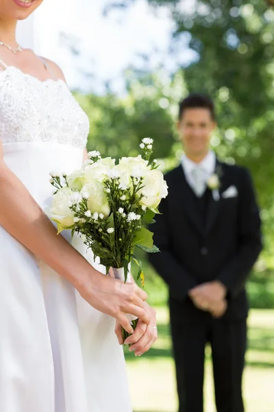 Braut hält Strauß mit Bräutigam — Stockfoto